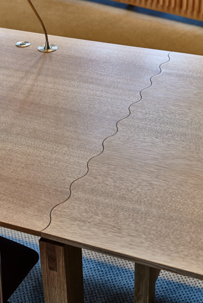 Detalje af bølgeformede samlinger inspireret af Vejle Å – håndværksdetalje på byrådsbord