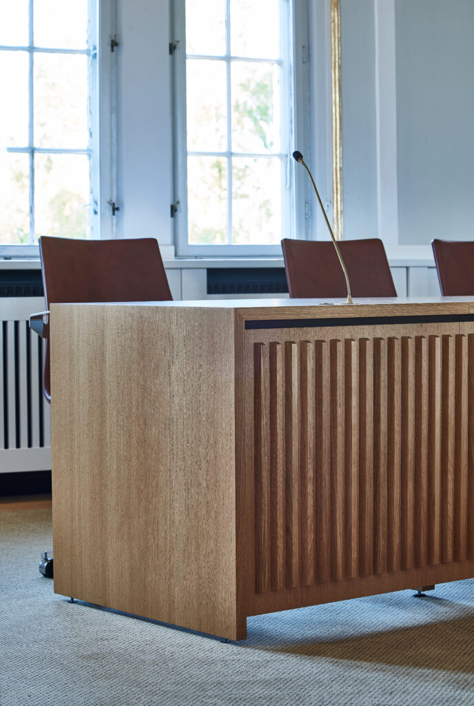 Front på byrådsbord med svævende udtryk og vertikale affasede lister – Tobleroneformet profil