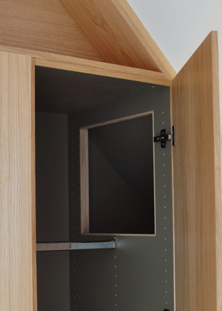 De trekantede fronter er faste, men er indrettet sådan, så man fra naboskabet kan lægge tøj ind over de lavere skabe og dermed udnytte alt pladsen