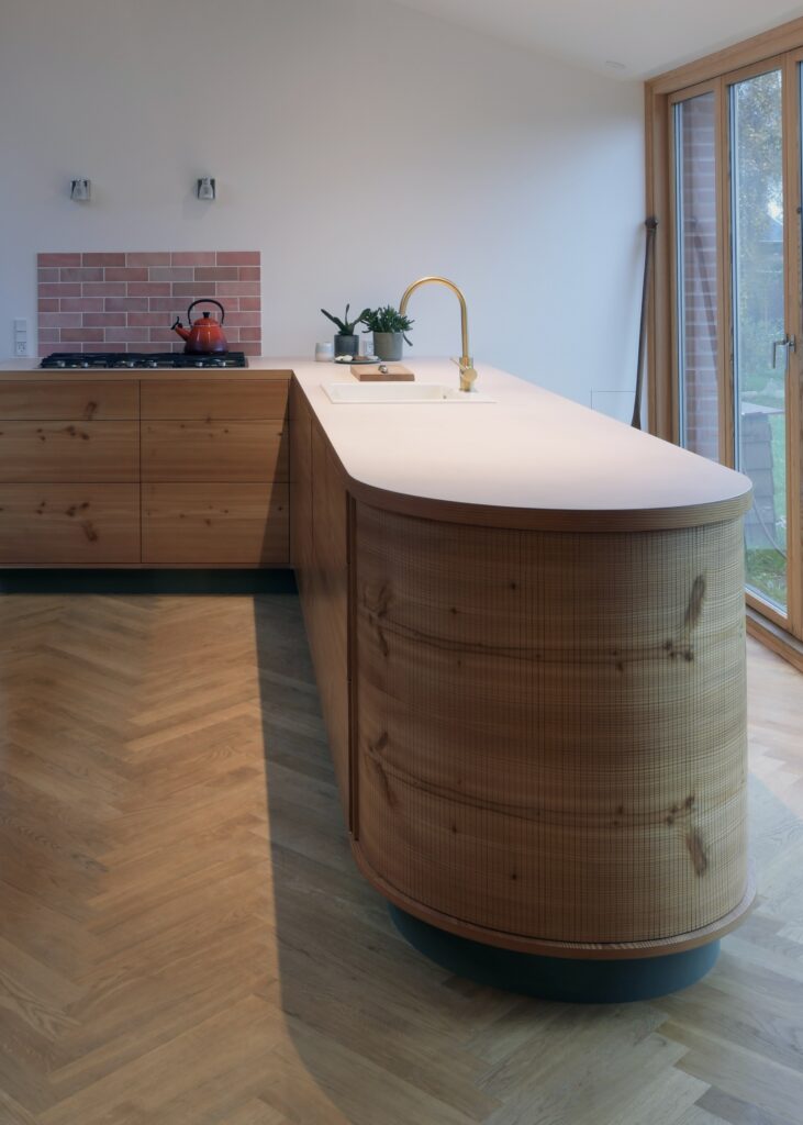 Køkkenø i douglastræ med vandret kørende jalousilåger og buede hjørner – specialdesignet løsning