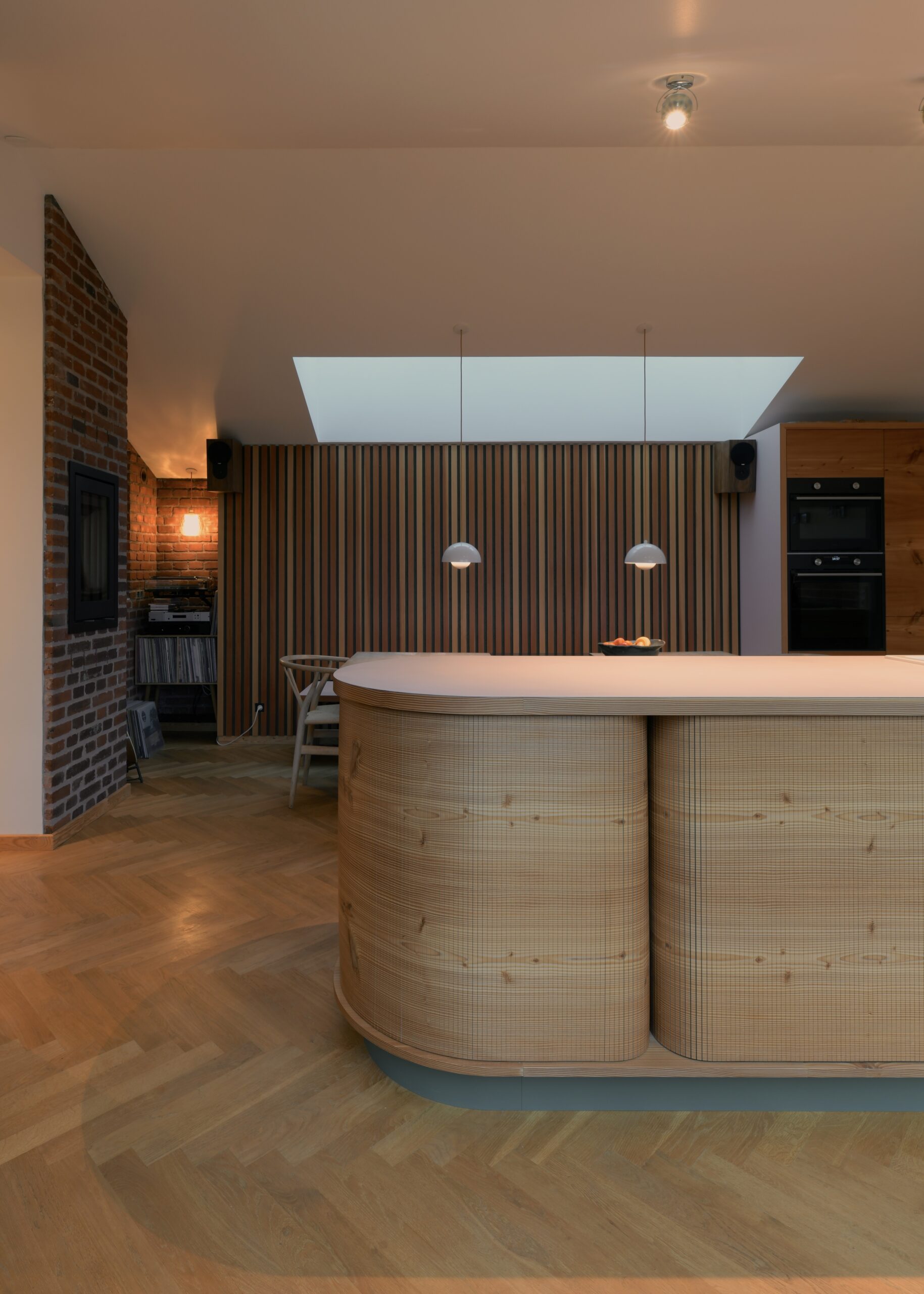 Køkkenø i douglastræ med vandret kørende jalousilåger og buede hjørner – specialdesignet løsning