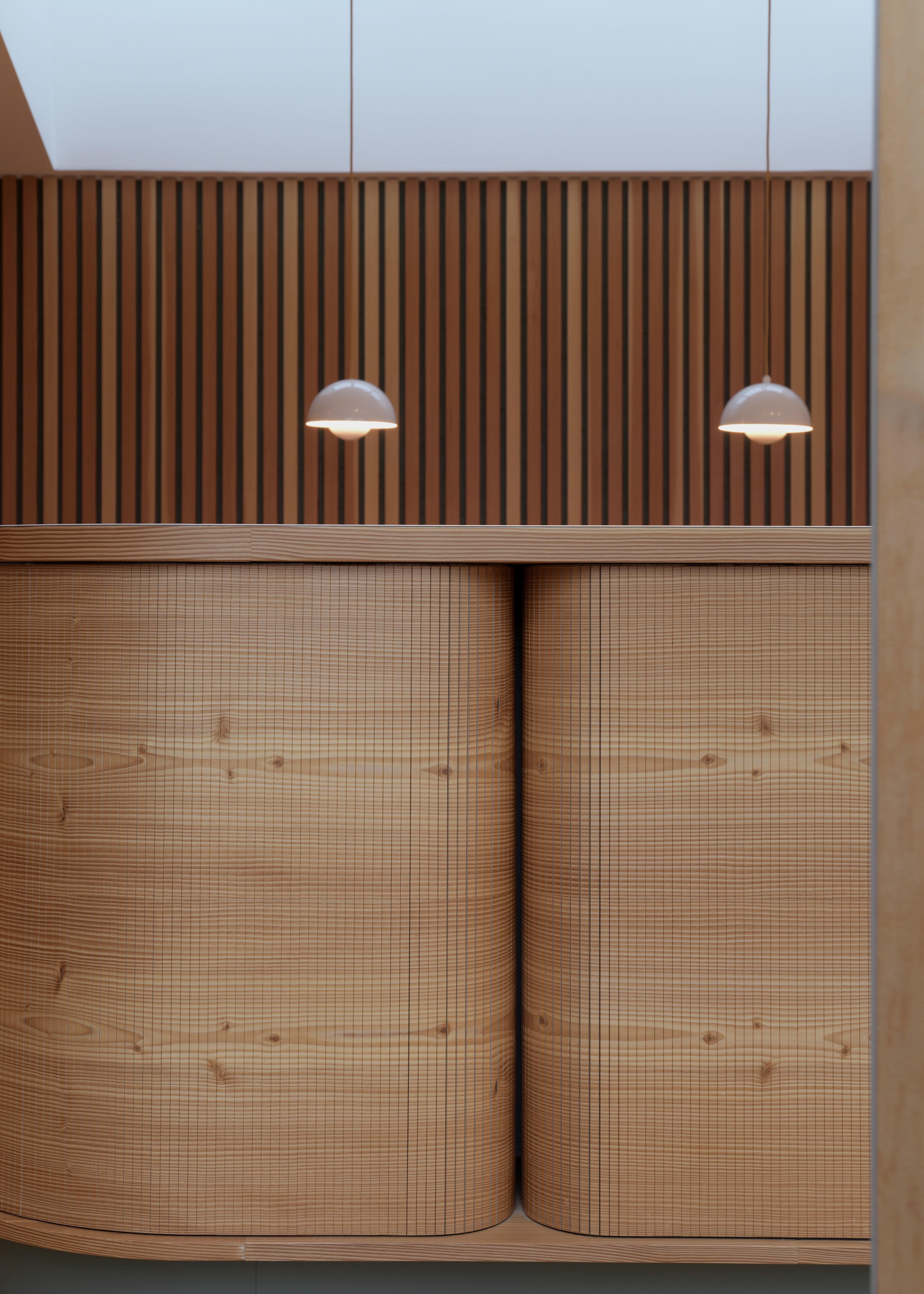 Køkkenø i douglastræ med vandret kørende jalousilåger og buede hjørner – specialdesignet løsning