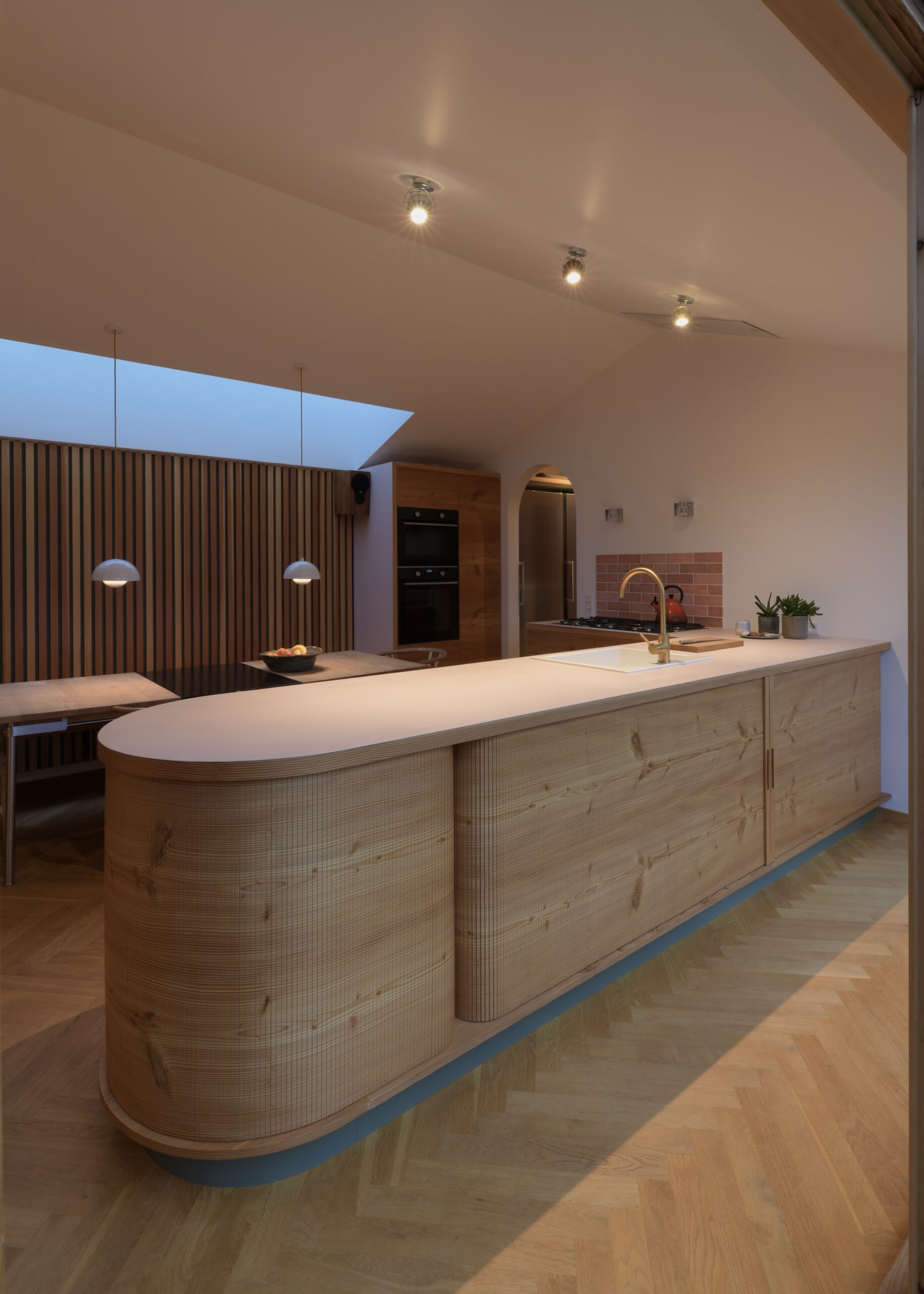 Køkkenø i douglastræ med vandret kørende jalousilåger og buede hjørner – specialdesignet løsning