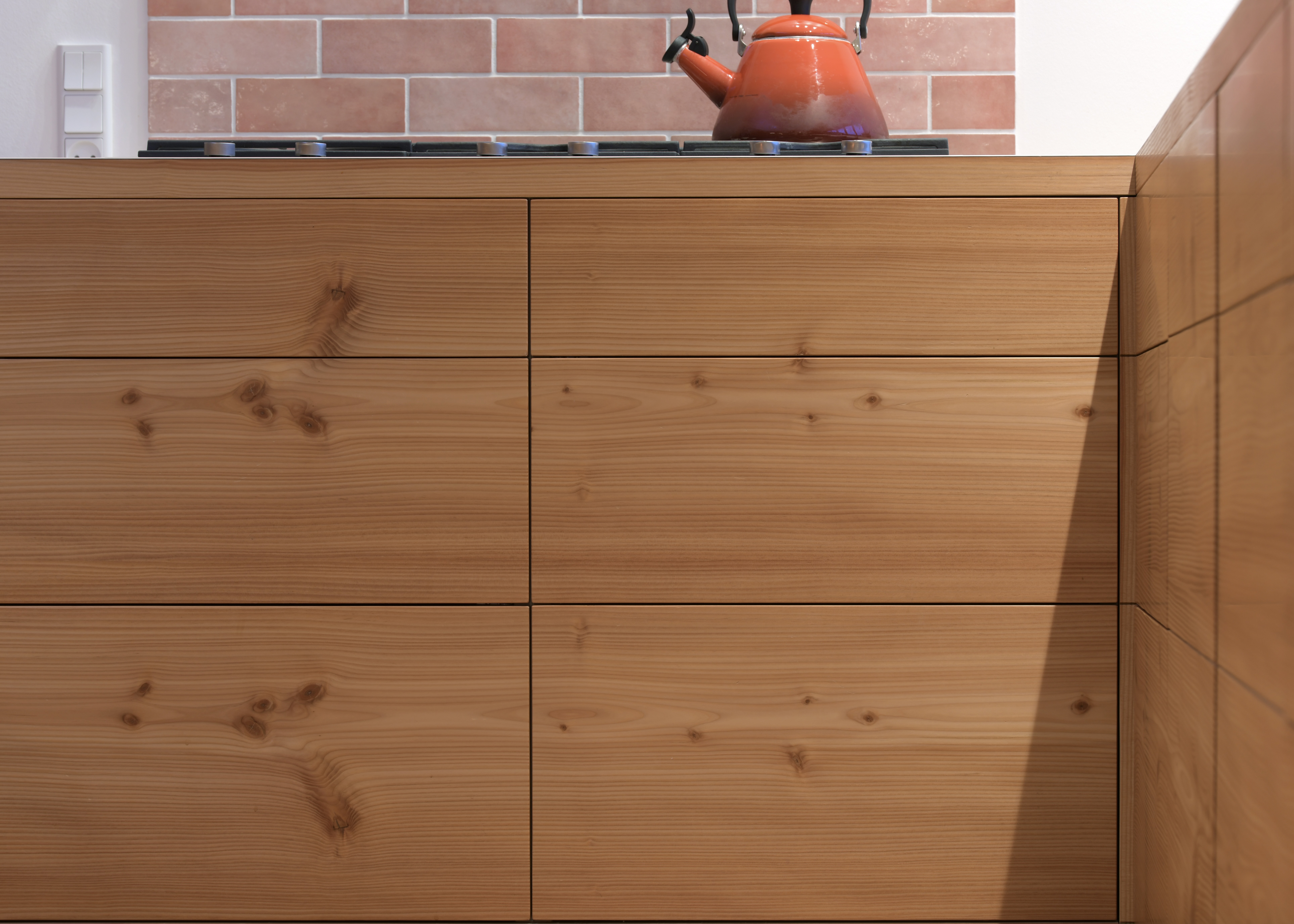 Køkkenø i douglastræ med vandret kørende jalousilåger og buede hjørner – specialdesignet løsning