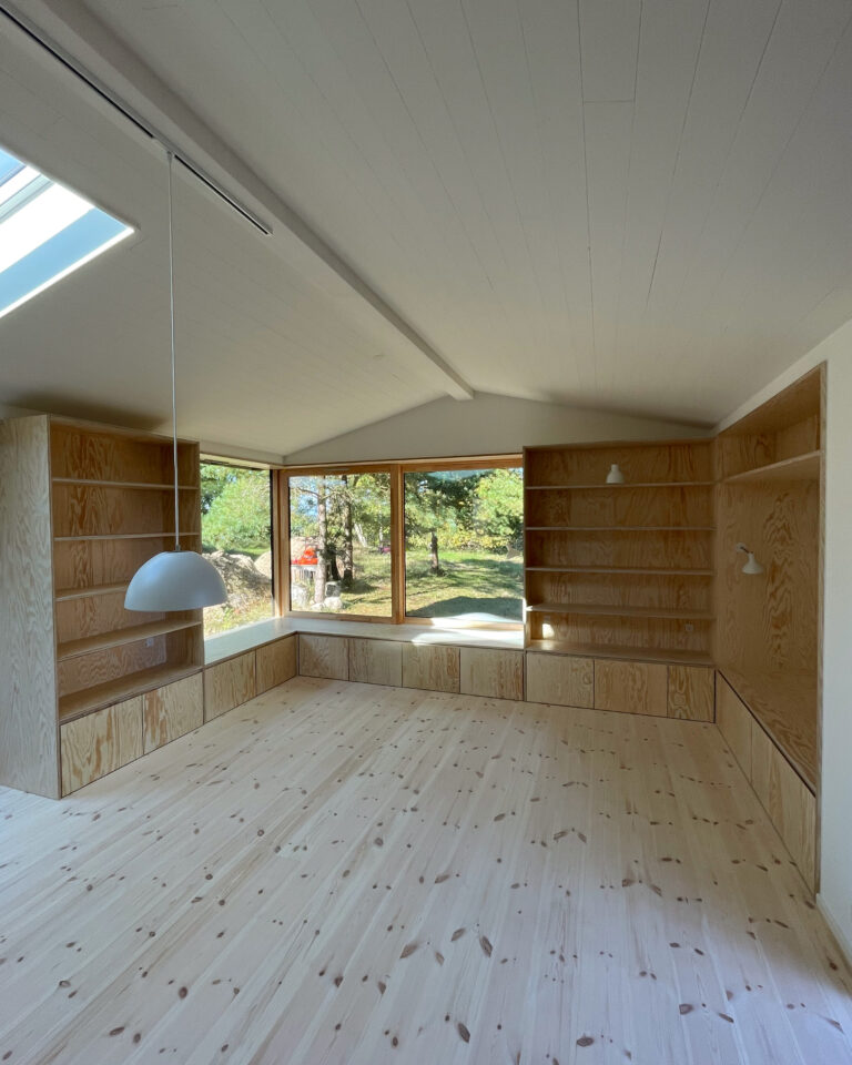 Stue i sommerhus med møbler i lyst fyrretræ